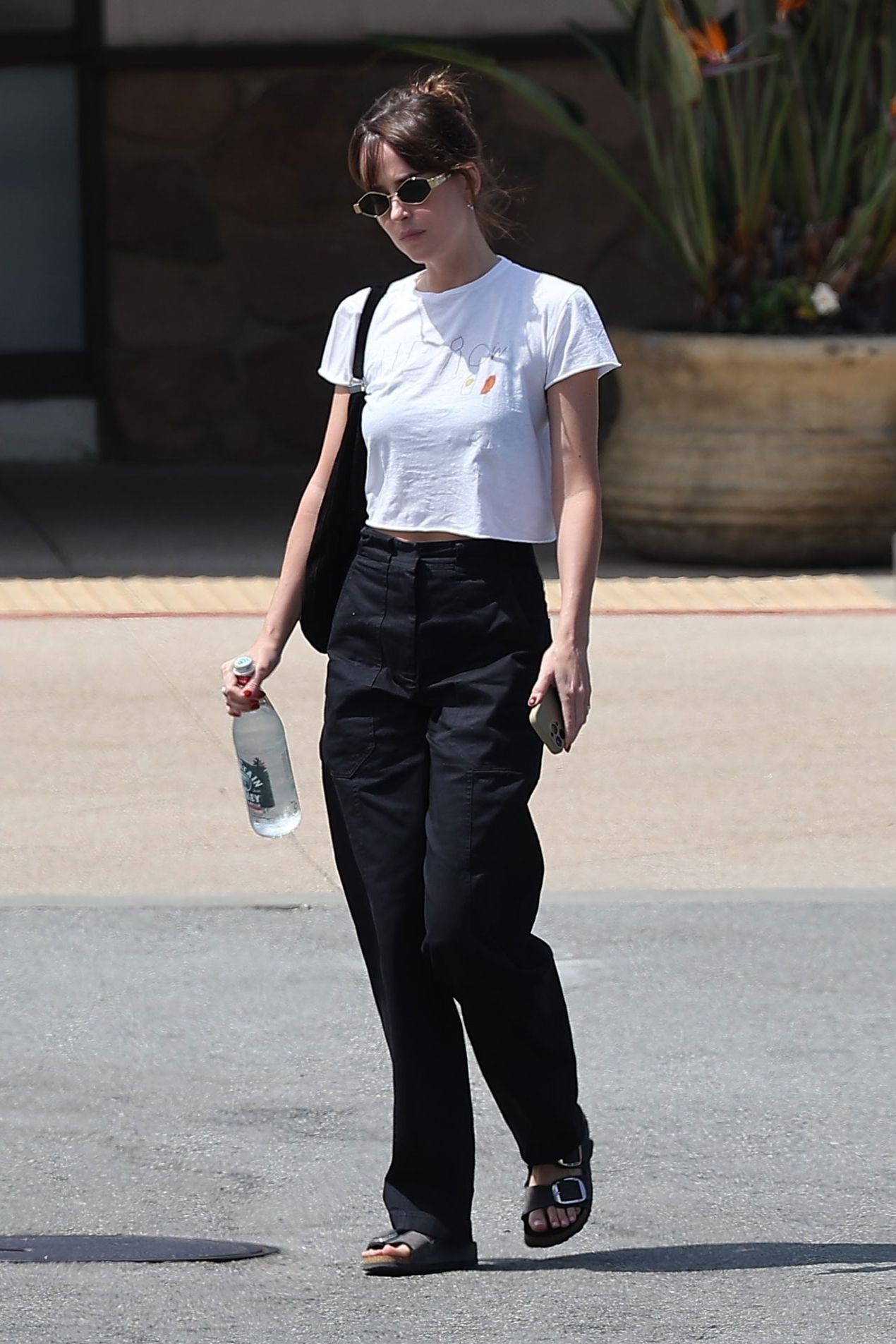 Image may contain Dakota Johnson Clothing Pants Pedestrian Person Teen Accessories Glasses Bag and Handbag